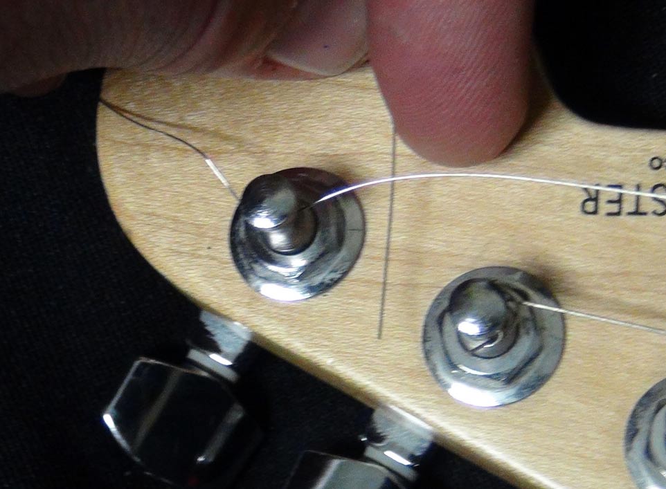 Pass the end of the string under the part of the string on the other side of the tuning peg.